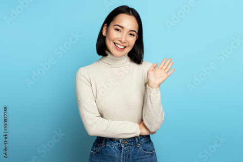Portrait of adorable friendly woman with brown hair standing waving hand