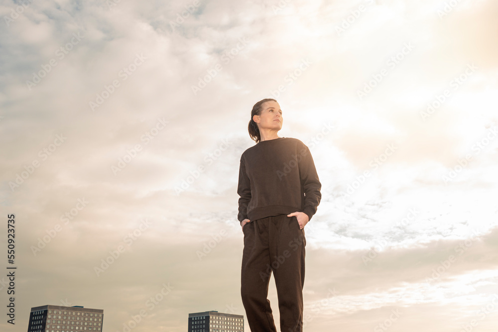 Fit sporty mid adult woman wearing a track suit outside. Preparing for exercise. Fit sporty mid adult woman wearing a track suit outside. Preparing for exercise.