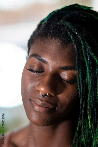 Black woman with green dreadlocks daydreaming