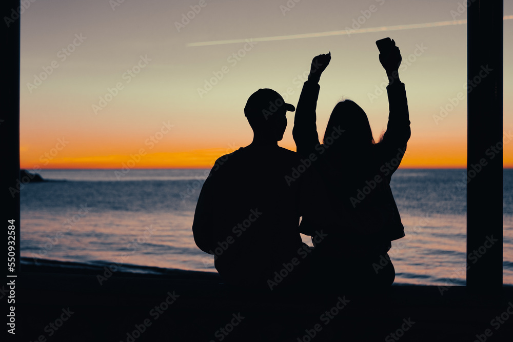 silhouette of two people at sunrise
