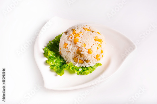 boiled rice with corn on a lettuce leaf. on a white background
