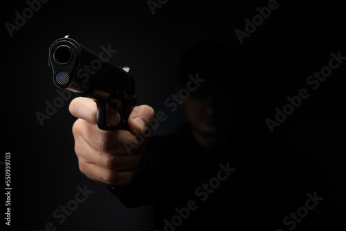 Close up of man hand with aiming gun on a black background.