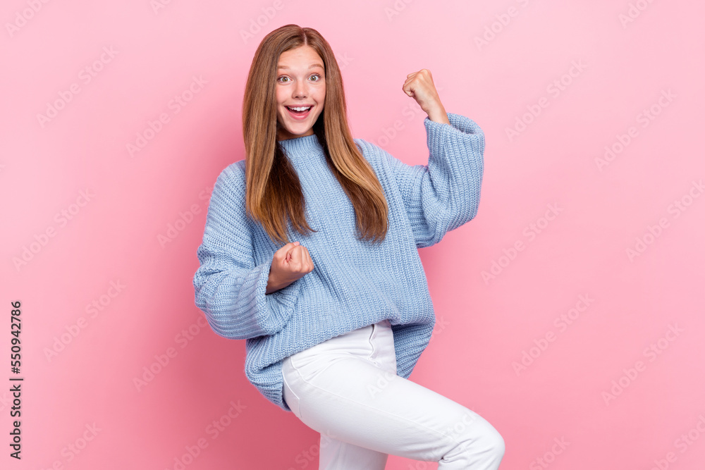 Photo of funky joyful schoolgirl wear blue knitted sweater fists up excited love her victories first place tournament isolated on pink color background Photo of funky joyful schoolgirl wear blue knitted sweater fists up excited love her victories first place tournament isolated on pink color background