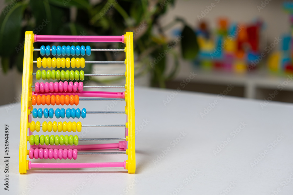 Colorful children's abacus on the table. Mathematics, arithmetic for preschool and school children, learning to count Colorful children's abacus on the table. Mathematics, arithmetic for preschool and school children, learning to count