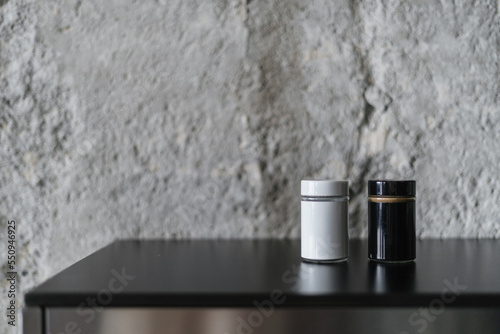 Salt and pepper shaker in black white jars standing on kitchen countertop