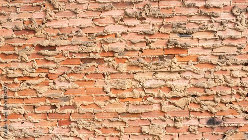 Muro de ladrillos con restos de argamasa y cemento