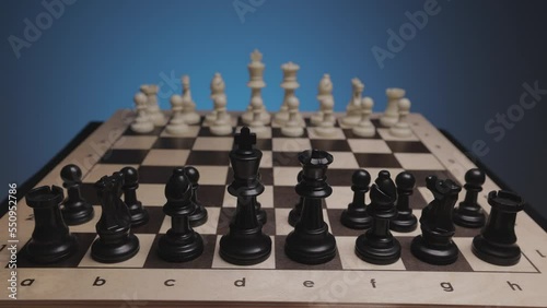Chess in slowmo falls off the board. The camera is fixed on a chessboard.