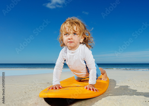 Canvas Print Little toddler girl already practicing push ups on the surfboard