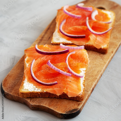Homemade Smoked Salmon Toast on a rustic wooden board, low angle view. Close-up.
