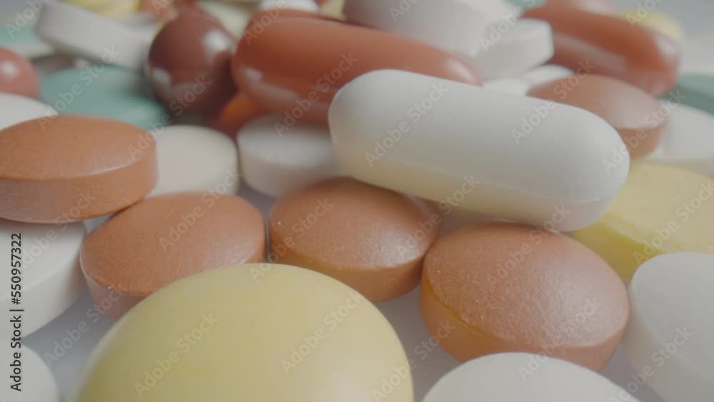 Medical tablets, pills and capsules rotating close up. White, blue and brown, round and oval assorted medicines. Vitamins, antibiotics, painkillers. Slow motion ready 59.94fps. Medical tablets, pills and capsules rotating close up. White, blue and brown, round and oval assorted medicines. Vitamins, antibiotics, painkillers. Slow motion ready 59.94fps.
