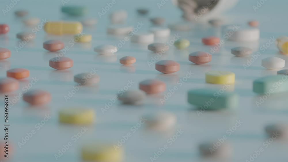 Various medical pills, capsules and tablets scattered on a table on a blue background with different depth of field. Brown, white and yellow medicines close up. Slow motion ready 59.94fps. Various medical pills, capsules and tablets scattered on a table on a blue background with different depth of field. Brown, white and yellow medicines close up. Slow motion ready 59.94fps.