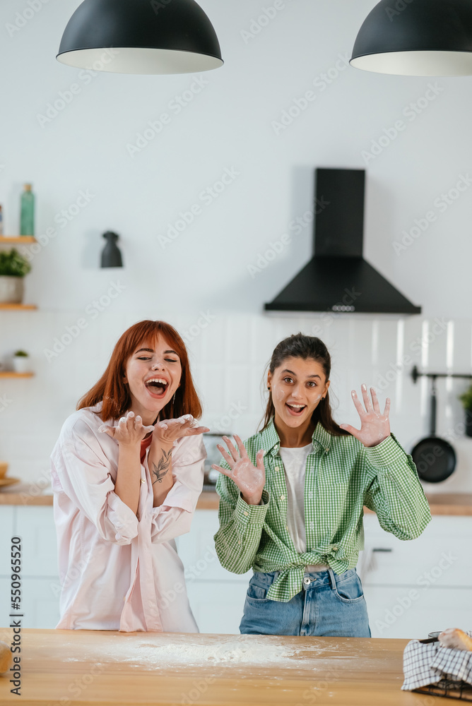 Two beautiful women play with flour in the kitchen Two beautiful women play with flour in the kitchen