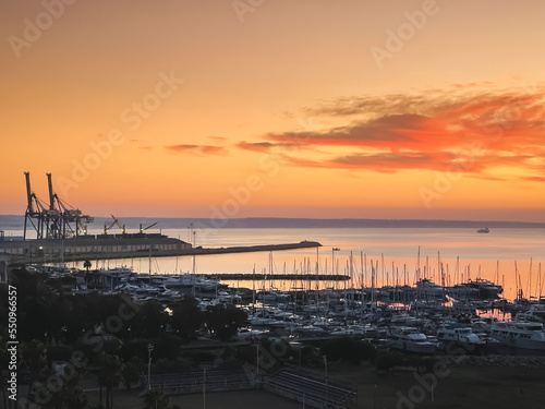 Yacht marina in sunset light  aerial drone flight. Bright orange sky and industrial port in Larnaca  Cyprus