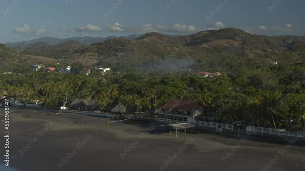 Aerial panning shot of shoreline at ocean beach waterfront / San Blas, La Libertad, El Salvador Aerial panning shot of shoreline at ocean beach waterfront / San Blas, La Libertad, El Salvador