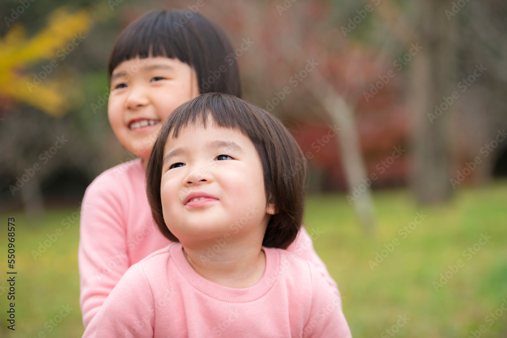 紅葉が綺麗な公園で自然を楽しむ小さな姉妹