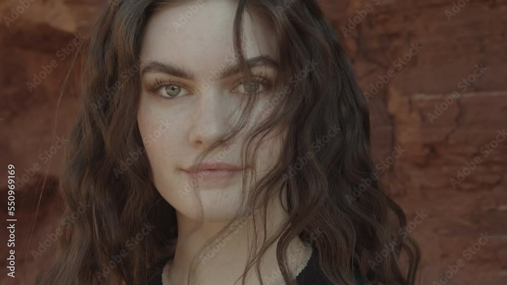 Close up of wind blowing hair on face of serious woman / Moab, Utah, United States