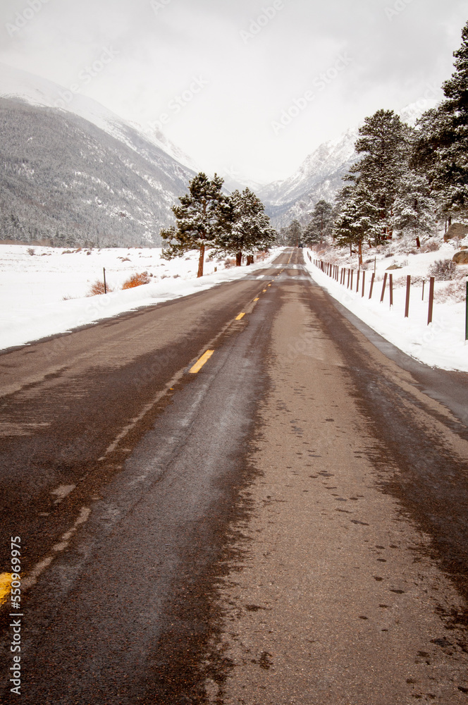 Looking down the middle of a snowy highway in Rocky Mountain National Park in the Winter, Estes Park, Colorado Looking down the middle of a snowy highway in Rocky Mountain National Park in the Winter, Estes Park, Colorado