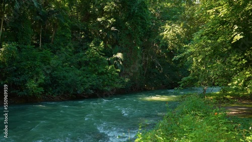 Martha Brae Rafting Village. Martha Brae River. Rafting on the Martha Brae. Montego Bay, Jamaica. A man runs a bamboo fence. Wooden raft.