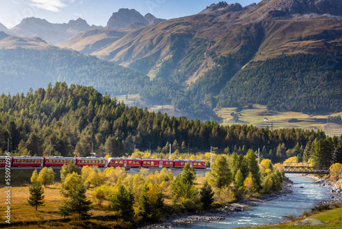 Swiss train in the alps and river around Bernina pass, Engadine, Switzerland photo
