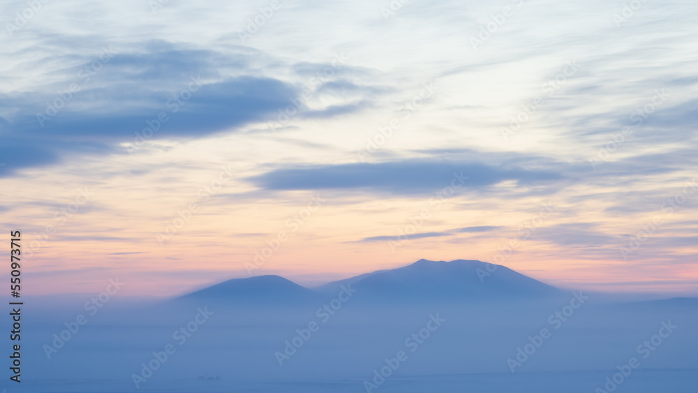 Winter arctic landscape. View of the snowy mountain. Polar twilight in the tundra. Cold frosty weather. Polar climate. Winter panorama. Nature of Siberia and the Russian Far East. Chukotka, Russia.