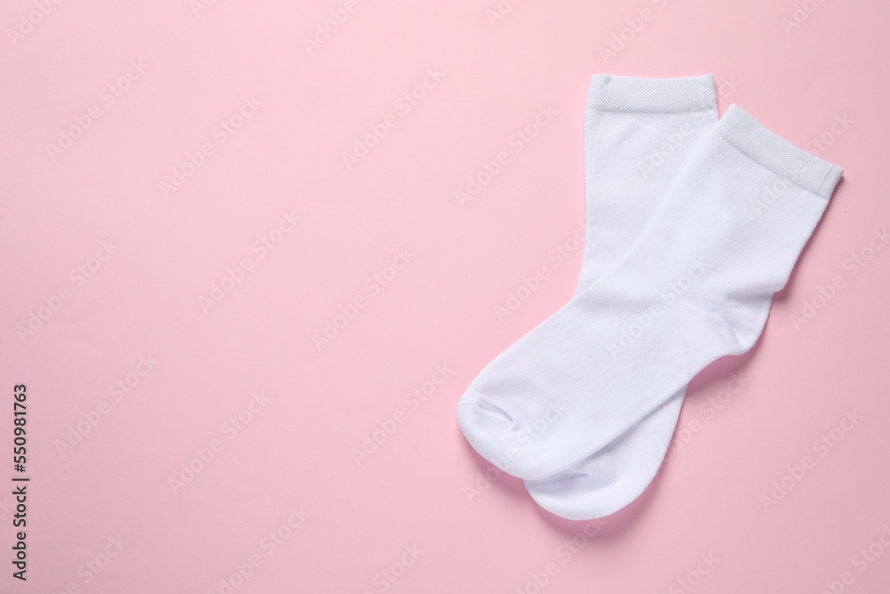 Pair of white socks on pink background, flat lay. Space for text Pair of white socks on pink background, flat lay. Space for text