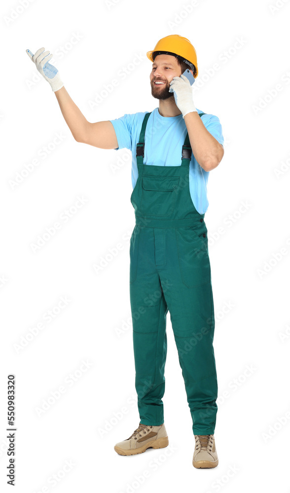 Professional repairman in uniform with smartphone on white background