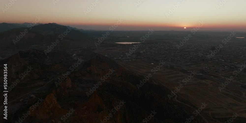 Aerial shot, drone follows a road with camera pointing down as it goes camera tilts revelaling village during sunrise golden Aerial shot, drone follows a road with camera pointing down as it goes camera tilts revelaling village during sunrise golden