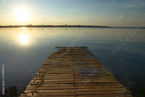 Fototapeta Naklejka Na Ścianę i Meble -  Wooden pier at sunset on a lake in Bueng Kan, Thailand 2022   