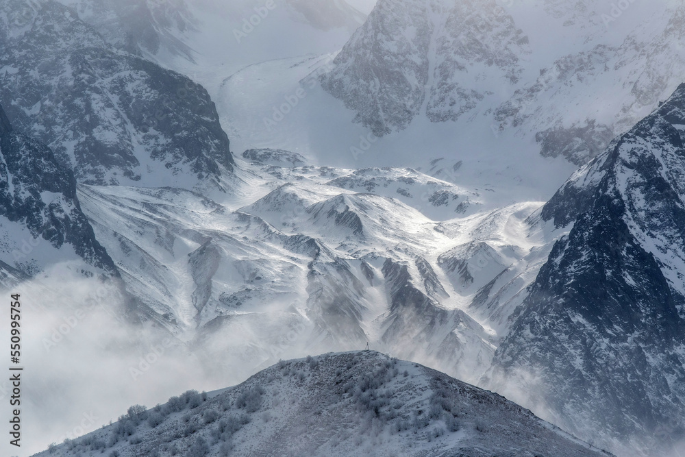 Obraz premium Lower part of West Kaysar glacier at stormy winter day. View from Kamunta village. Mountain Digoria, North Ossetia, Russia.