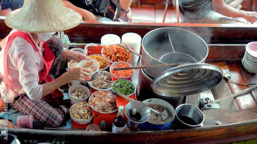 Sellers selling Thai noodle on boats, Ancient travel destination of Thailand Damnoen saduak flating market, Ratchaburi Thailand. photo