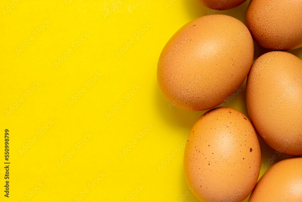 Brown chicken eggs on yellow background. Fresh chicken eggs background. Top view with copy space Brown chicken eggs on yellow background. Fresh chicken eggs background. Top view with copy space