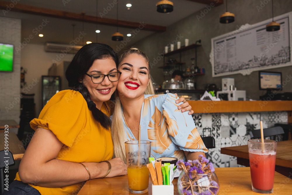 Two friends hugging in a bar