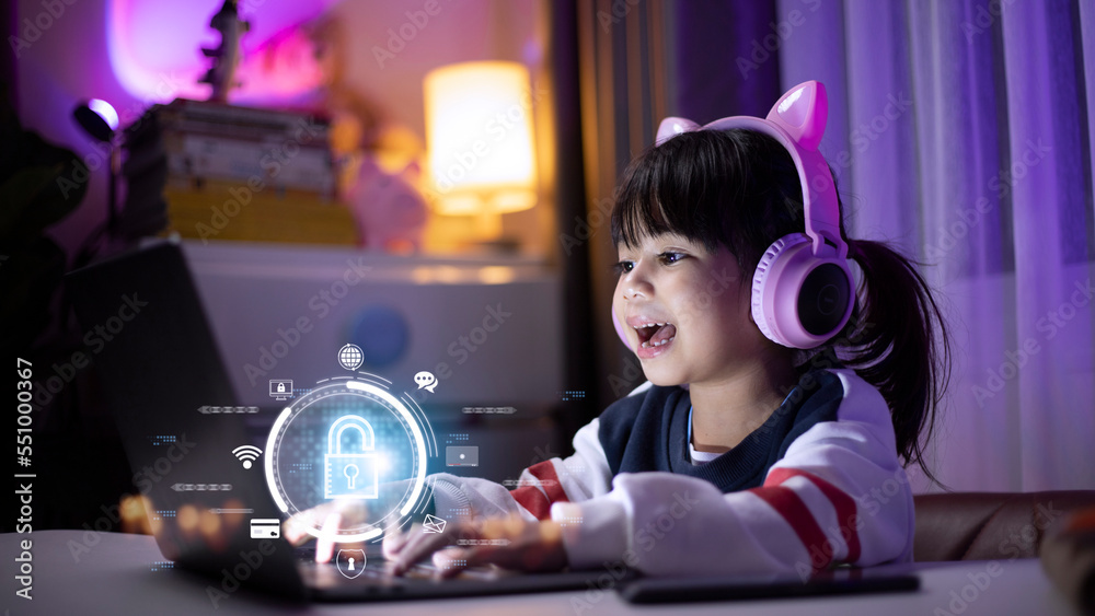 Child safety online. Little girl using laptop at home. icon of internet blocking app on foreground Child safety online. Little girl using laptop at home. icon of internet blocking app on foreground