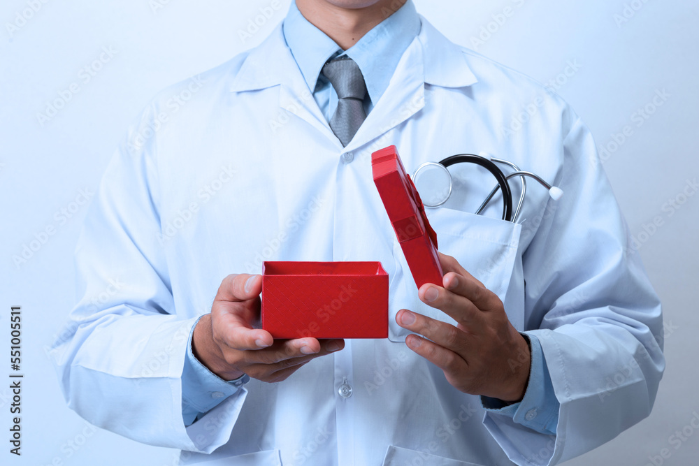 Doctor holding a gift box, healthy as a gift from a doctor Doctor holding a gift box, healthy as a gift from a doctor