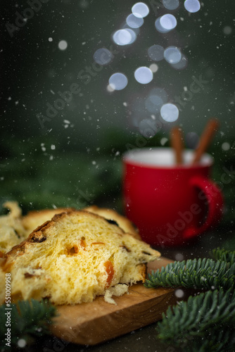 Pieces of Christmas cake on a board, a red cup of tea and blurred lights like steam, Merry Christmas and Happy New Year