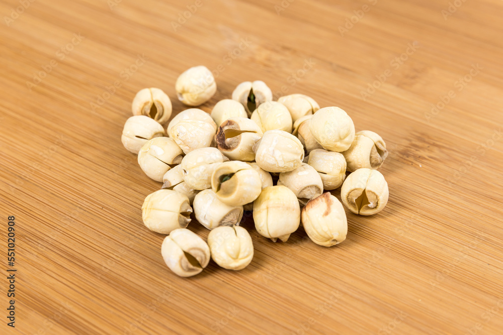 Lotus seed pile on a wood cutting board side view