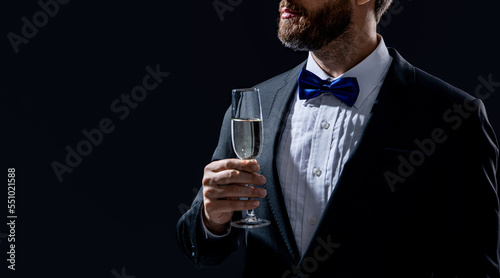 tuxedo man cheering in studio with copy space. tuxedo man cheering with champagne.