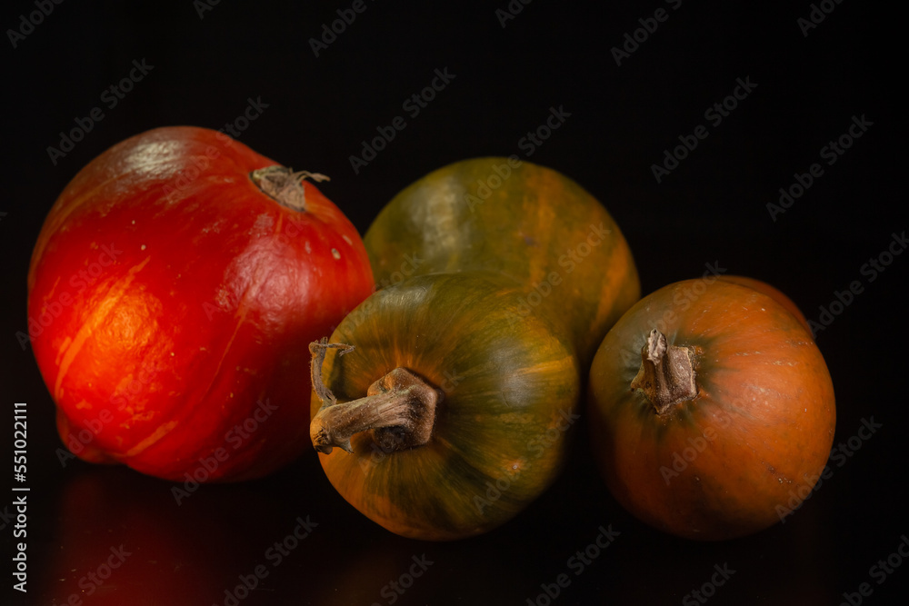 Yellow-orange pumpkins on a black background the concept of Halloween and the autumn harvest of pumpkin close-up copyspace from above Yellow-orange pumpkins on a black background the concept of Halloween and the autumn harvest of pumpkin close-up copyspace from above
