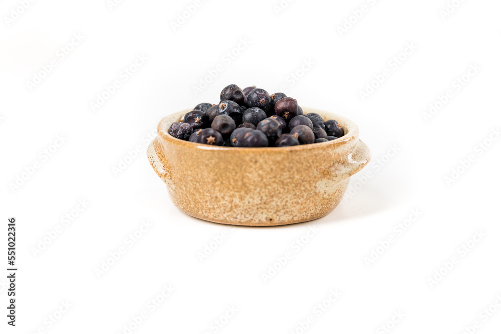 Juniper berries in a ceramic bowl isolated over white Juniper berries in a ceramic bowl isolated over white