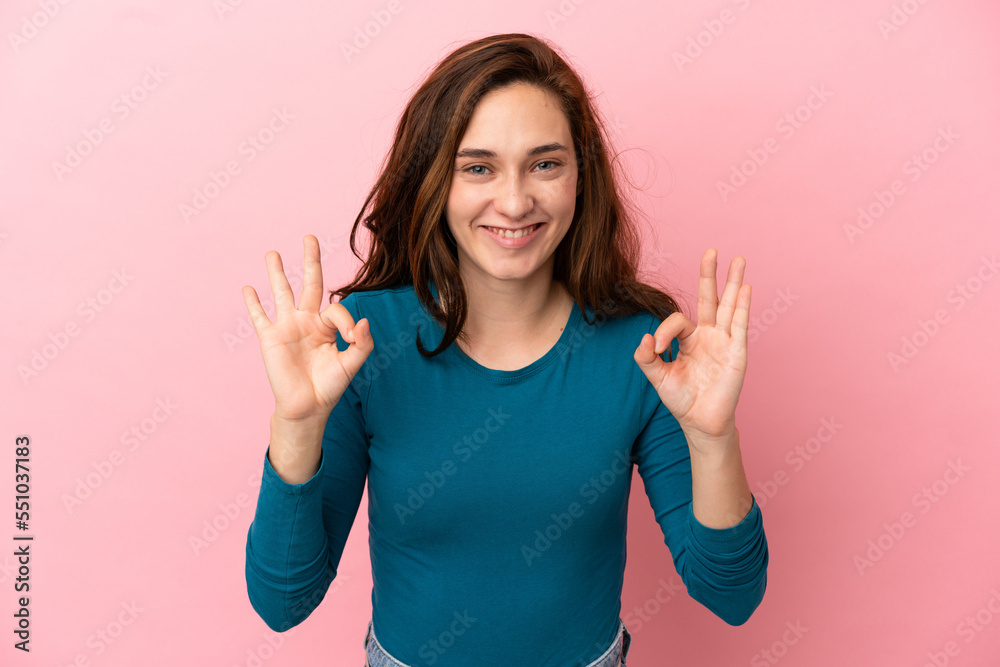 Young caucasian woman isolated on pink background showing ok sign with two hands Young caucasian woman isolated on pink background showing ok sign with two hands