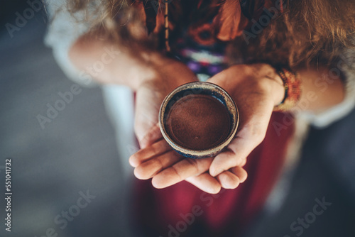 Cacao ceremony, heart opening medicine. Ceremony space. Cacao cup in woman's hand.