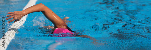 Swimmer woman athlete swimming in pool lanes doing a crawl lap. Swim race freestyle. Triathlete training for triathlon