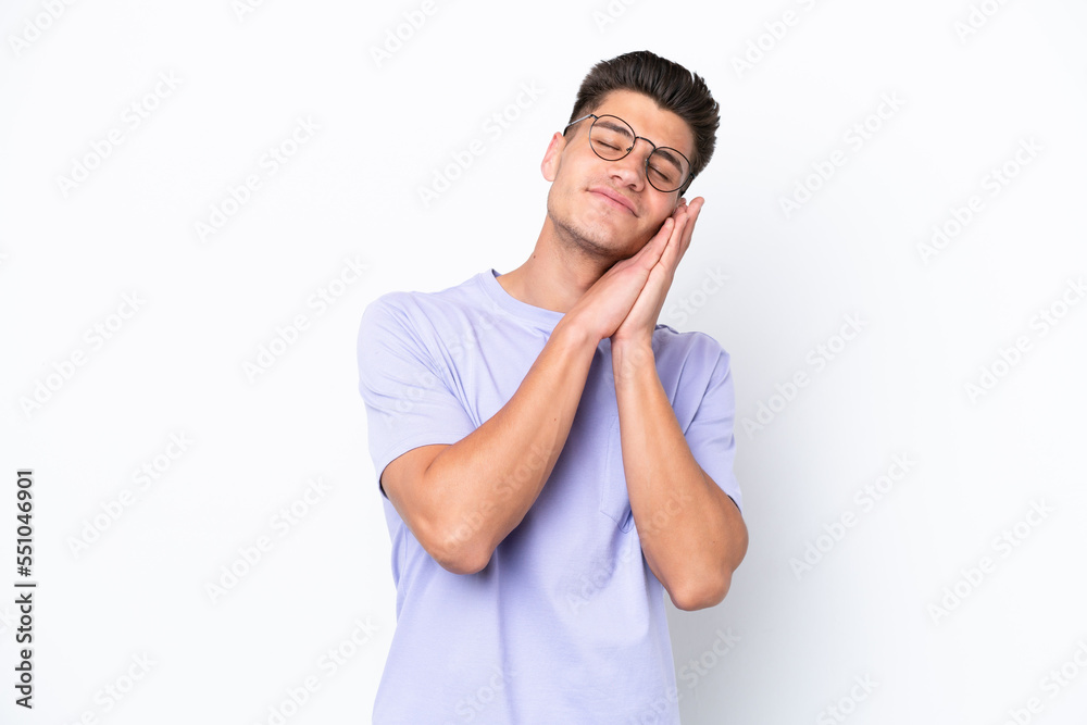 Young caucasian man isolated on white background making sleep gesture in dorable expression Young caucasian man isolated on white background making sleep gesture in dorable expression