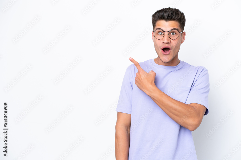 Young caucasian man isolated on white background surprised and pointing side Young caucasian man isolated on white background surprised and pointing side