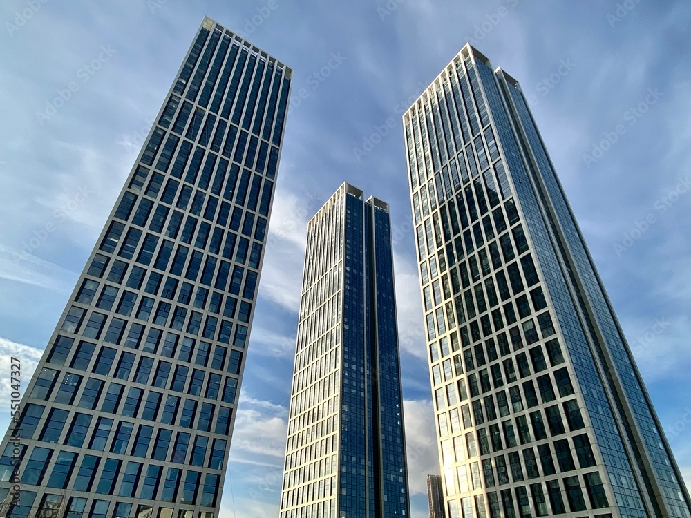 High-rise office and residential skyscrapers against the backdrop of a clear blue sky. Commercial real estate. Modern business district of the city. Exterior view of modern buildings.