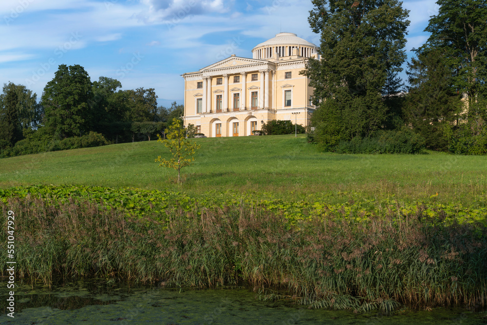 Fototapeta premium View of the Summer Palace of Emperor Paul I in Pavlovsky park from the Slavyanka River on a sunny summer day, Pavlovsk, Saint Petersburg, Russia