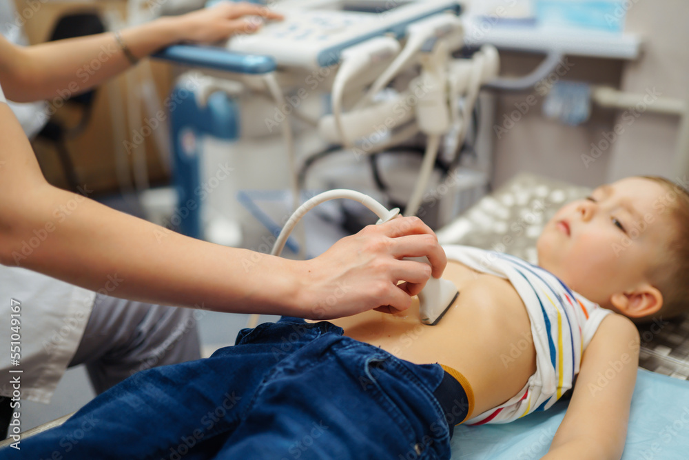 Little boy undergoing ultrasound at clinic. doctor making abdominal cavity sonogram for child Little boy undergoing ultrasound at clinic. doctor making abdominal cavity sonogram for child