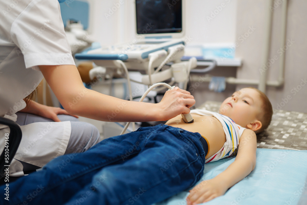 Obraz premium Little boy undergoing ultrasound at clinic. doctor making abdominal cavity sonogram for child