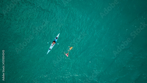 Top view of a man paddles a kayak in raging sea water