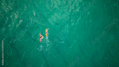 Top drone view ,Two female swimmers swim in the open sea
